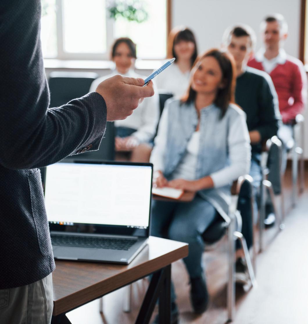 Everyone is smiling and listens. Group of people at business conference in modern classroom at daytime Everyone is smiling and listens. Group of people at business conference in modern classroom at daytime.